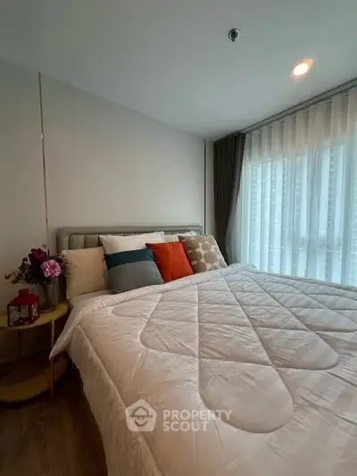 Cozy bedroom with modern decor and large window for natural light