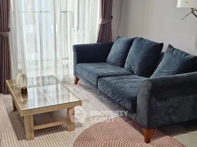 Stylish living room with plush sofa and modern coffee table in a bright, airy space.