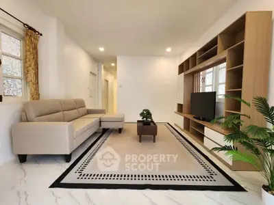 Spacious modern living room with elegant beige sofa and stylish entertainment unit.
