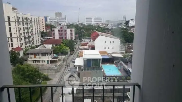 Stunning cityscape view from a high-rise balcony overlooking a vibrant urban neighborhood.