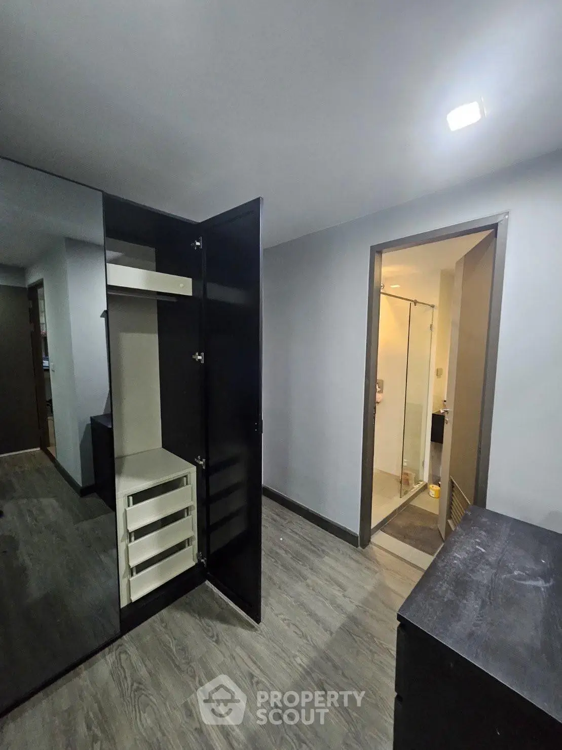 Modern apartment interior with open closet and view into bathroom
