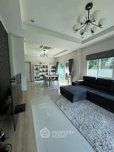 Spacious modern living room with elegant decor and large windows offering natural light.