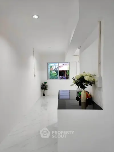 Minimalist kitchen with sleek black countertop and white marble flooring