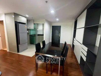 Modern dining area with sleek furniture and open kitchen layout in a stylish apartment.