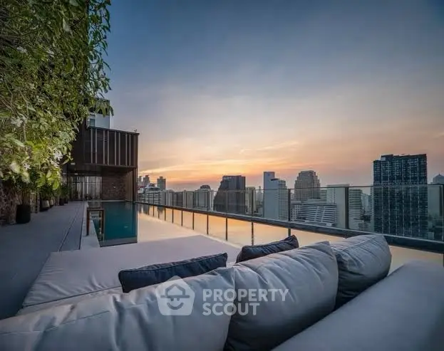 Luxurious rooftop with stunning city skyline view and infinity pool at sunset.