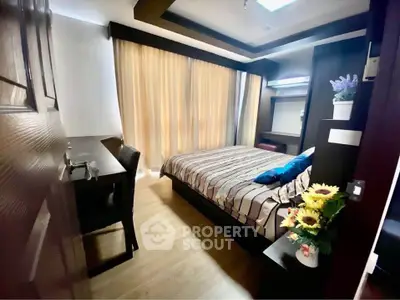 Cozy bedroom with modern decor and ample natural light from large window.
