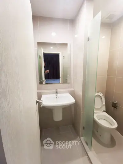 Modern compact bathroom with sleek fixtures and glass partition