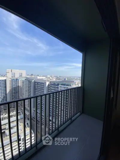 Stunning high-rise balcony view with cityscape and clear blue sky.