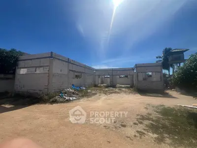 Unfinished construction site under a clear blue sky, showcasing potential for development.