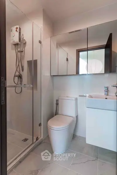 Modern bathroom with glass shower and sleek fixtures in a contemporary home.