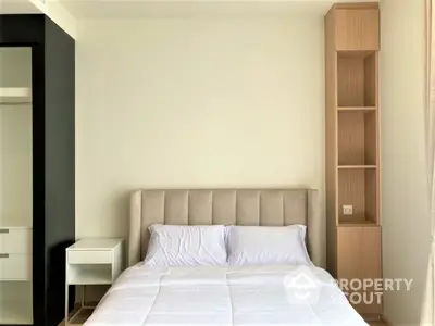 Minimalist bedroom with a large comfortable bed, crisp white bedding, sleek wooden shelving, and a modern aesthetic.