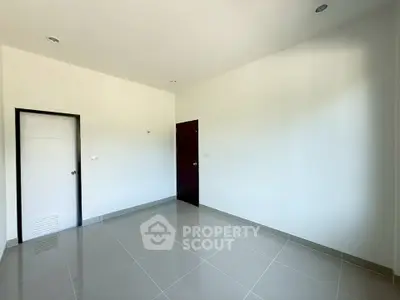 Spacious empty room with glossy tiled floor and white walls, ready for customization.