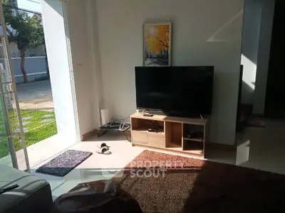 Cozy living room with TV and natural light, perfect for relaxation