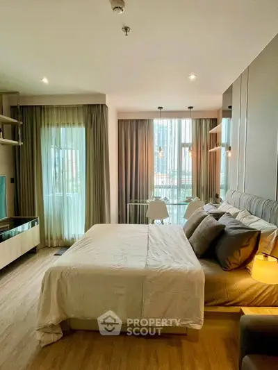 Modern bedroom with stylish decor and large windows offering natural light.