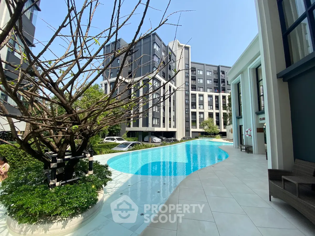 Luxurious modern apartment complex with stunning pool and elegant architecture.