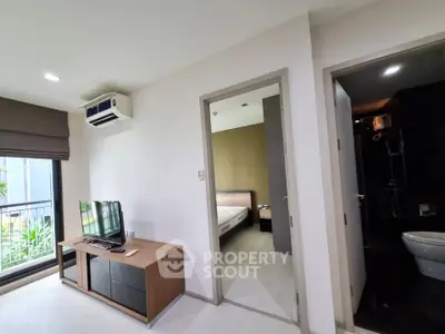 Modern apartment interior with living room, bedroom, and bathroom, featuring sleek furniture and natural light.