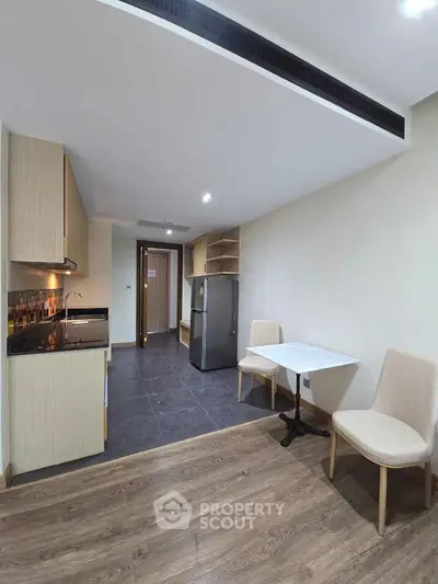 Modern kitchen with dining area and sleek appliances in cozy apartment
