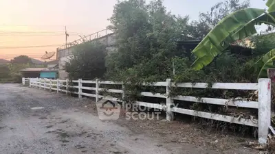 Charming rustic property with white picket fence and lush greenery, perfect for serene living.