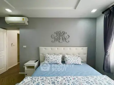 Cozy bedroom with elegant decor and air conditioning, featuring a plush bed and stylish wall art.