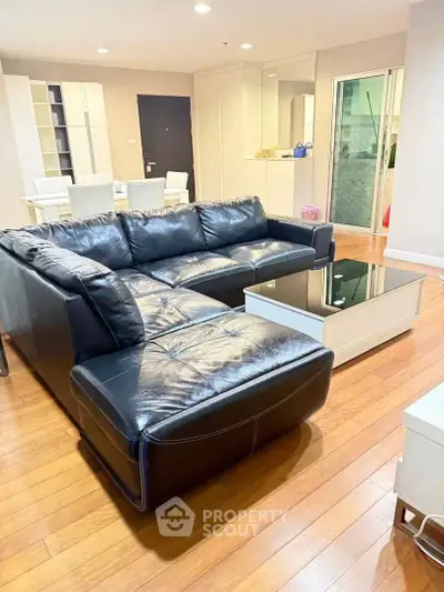 Spacious living room with sleek black leather sofa and modern decor