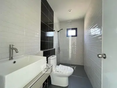 Modern bathroom with sleek fixtures and stylish black and white tile design.