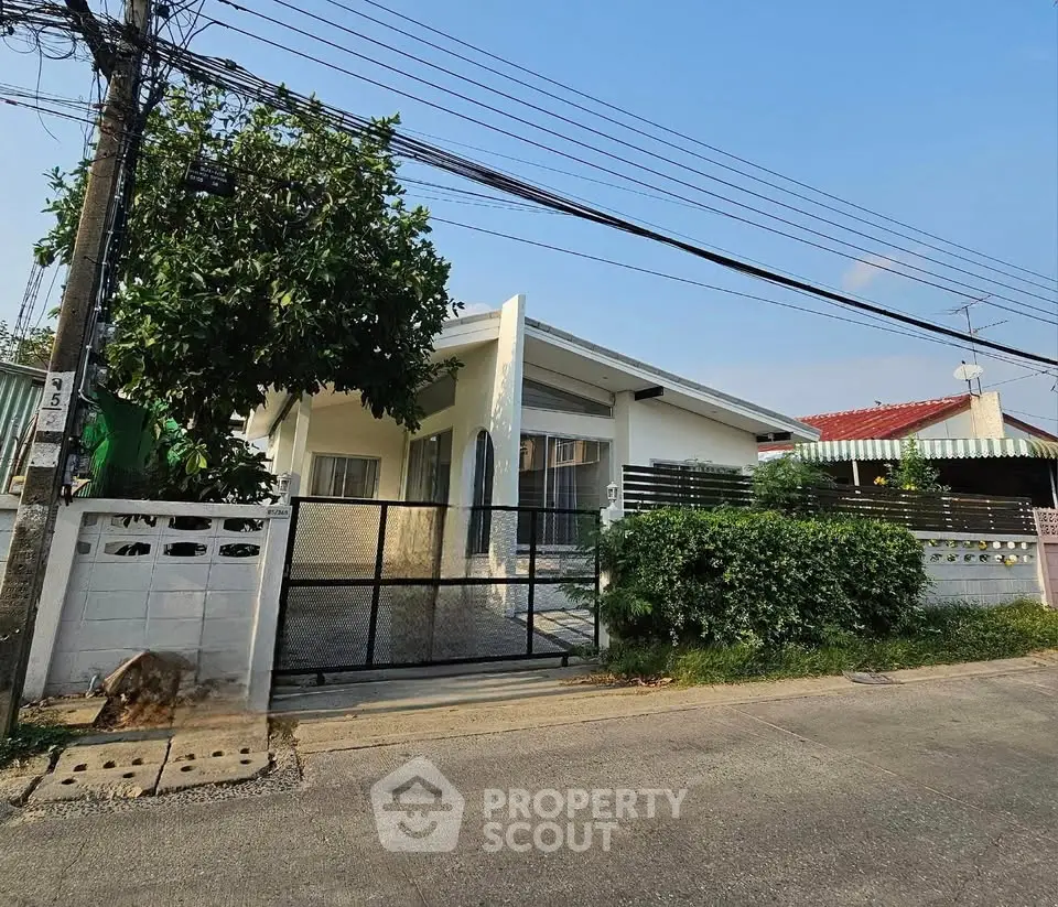 Charming single-story home with lush greenery and modern facade in a serene neighborhood.