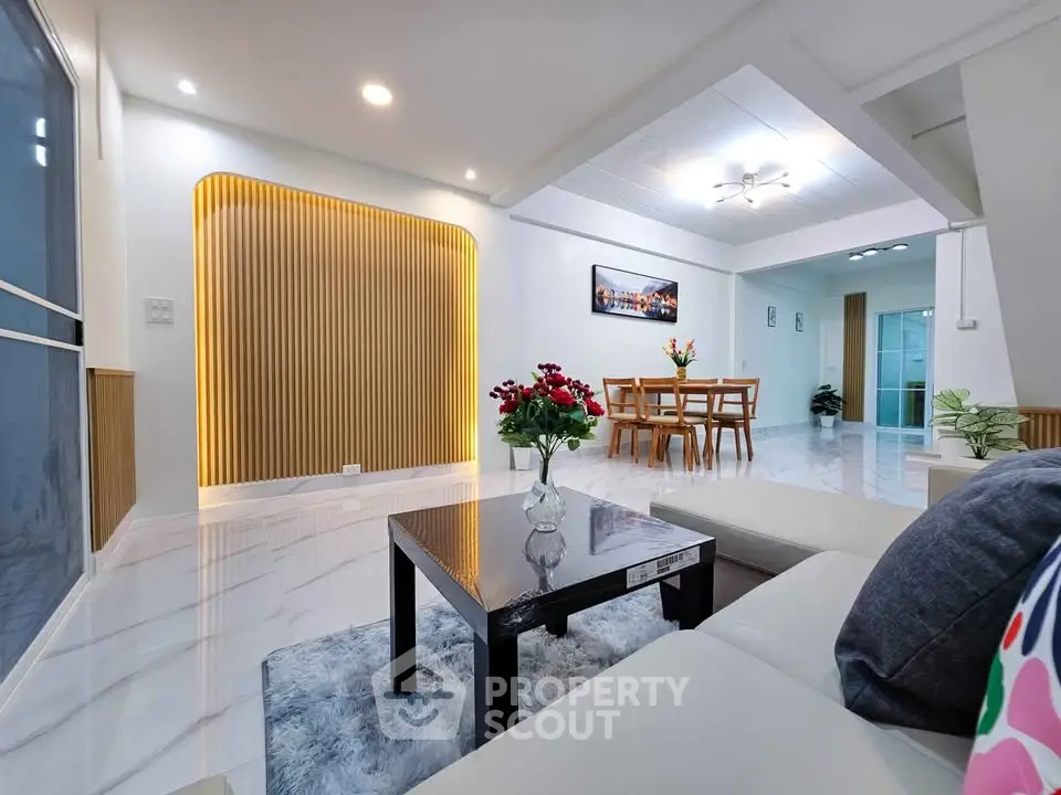 Spacious modern living room with elegant decor and open dining area, perfect for family gatherings.
