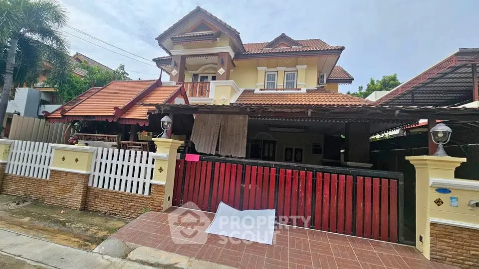 Charming two-story house with red-tiled roof and spacious front yard in a serene neighborhood.
