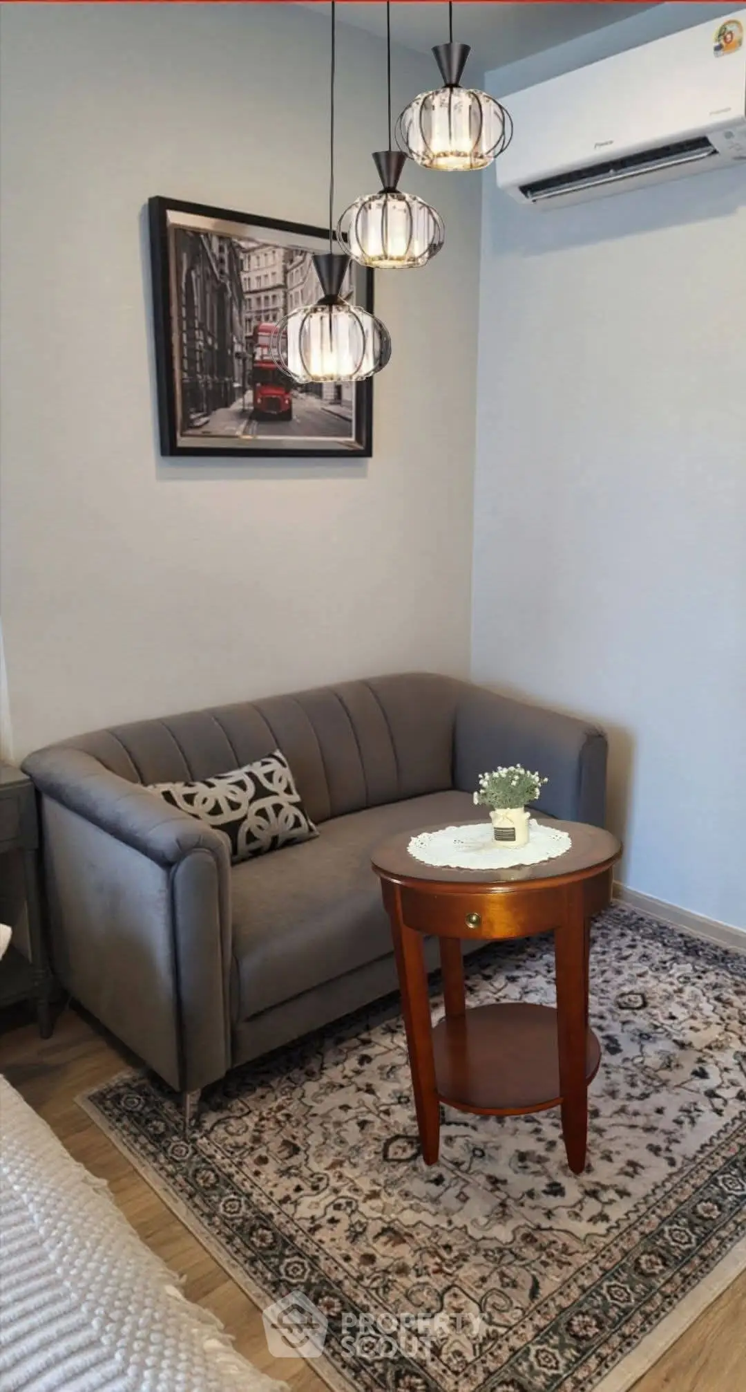 Charming living room with cozy gray sofa, elegant lighting, and stylish decor for a welcoming ambiance.