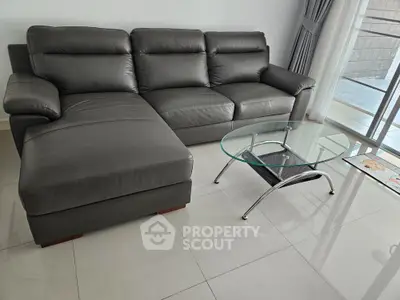 Modern living room with sleek leather sofa and glass coffee table