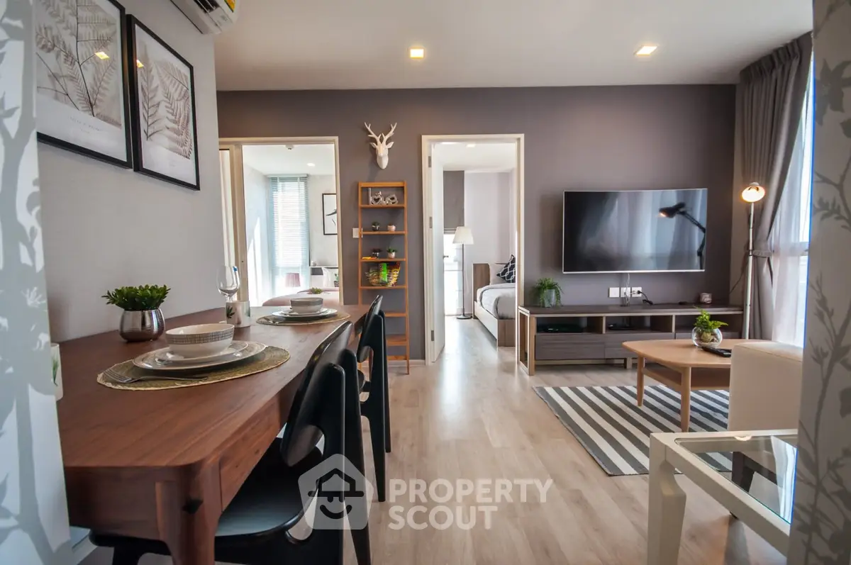 Modern living room with stylish decor and open layout, featuring a dining area and wall-mounted TV.