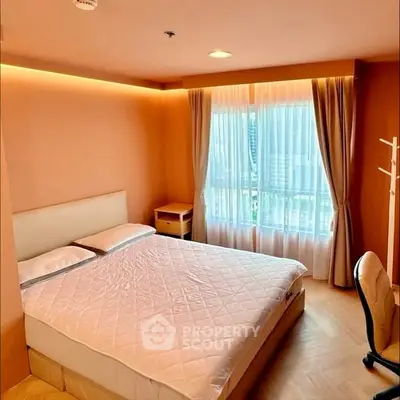 Cozy bedroom with large window and modern furnishings in a stylish apartment.