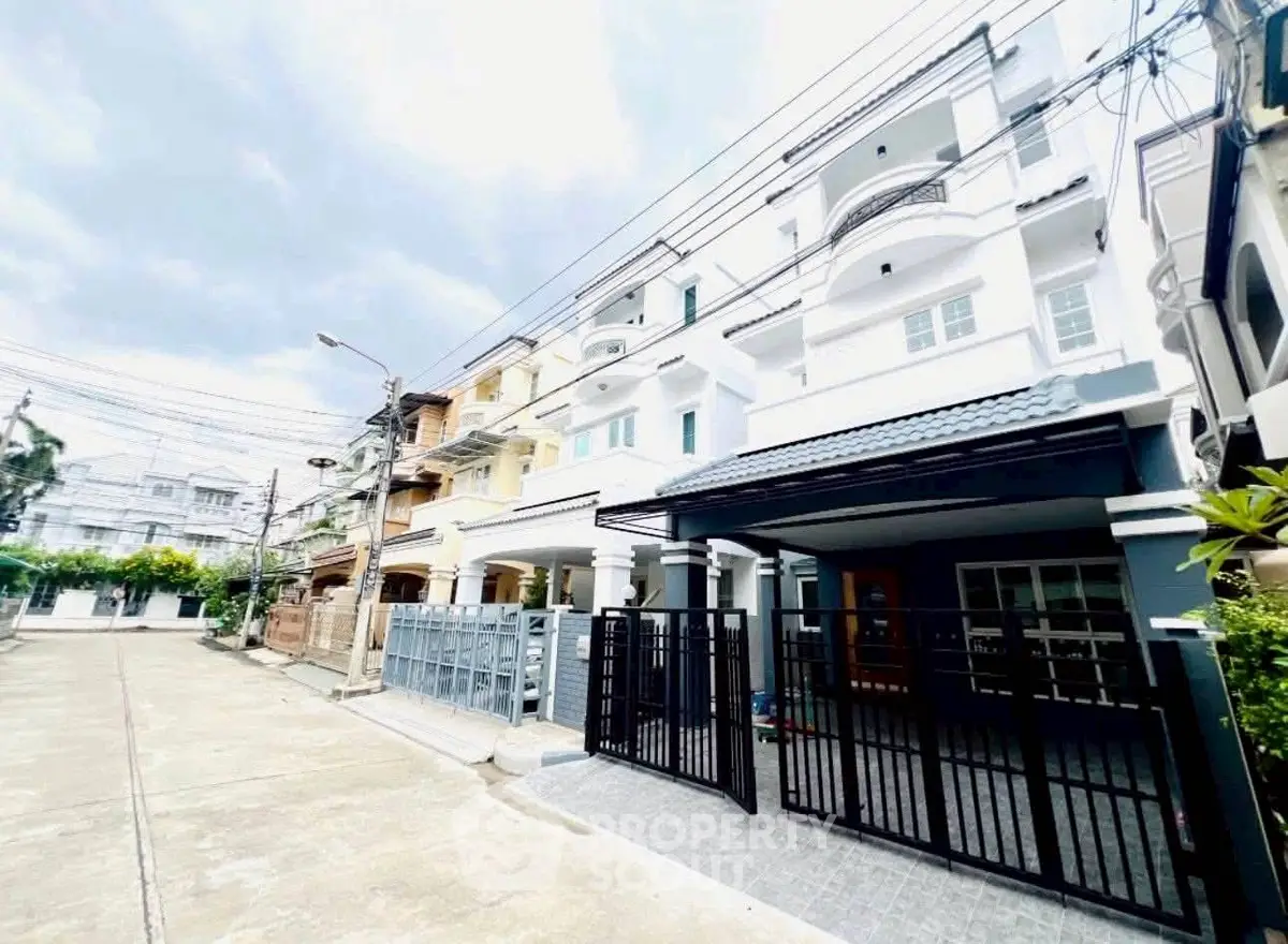 Modern multi-story townhouse with gated entrance in urban neighborhood