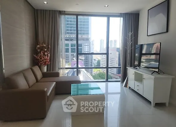 Modern living room with city view, sleek furniture, and large windows.