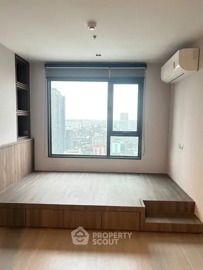 Spacious modern living room with large windows and stunning city view.