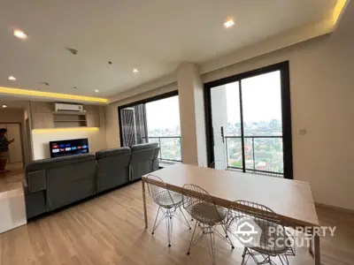 Modern living room with city view and stylish dining area in high-rise apartment