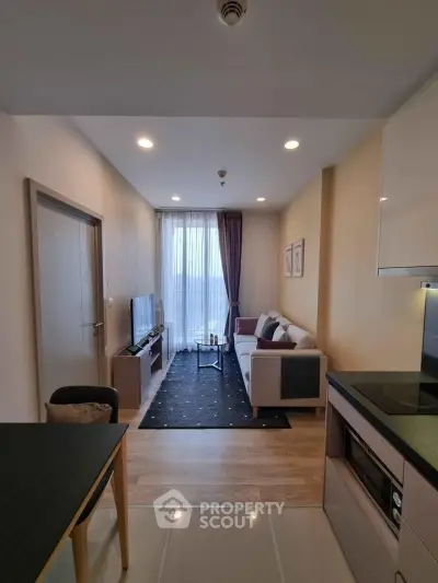 Modern living room with cozy sofa, TV, and dining area in open layout apartment.