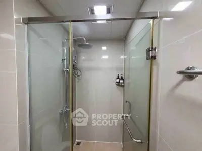 Modern bathroom with glass shower enclosure and sleek fixtures.