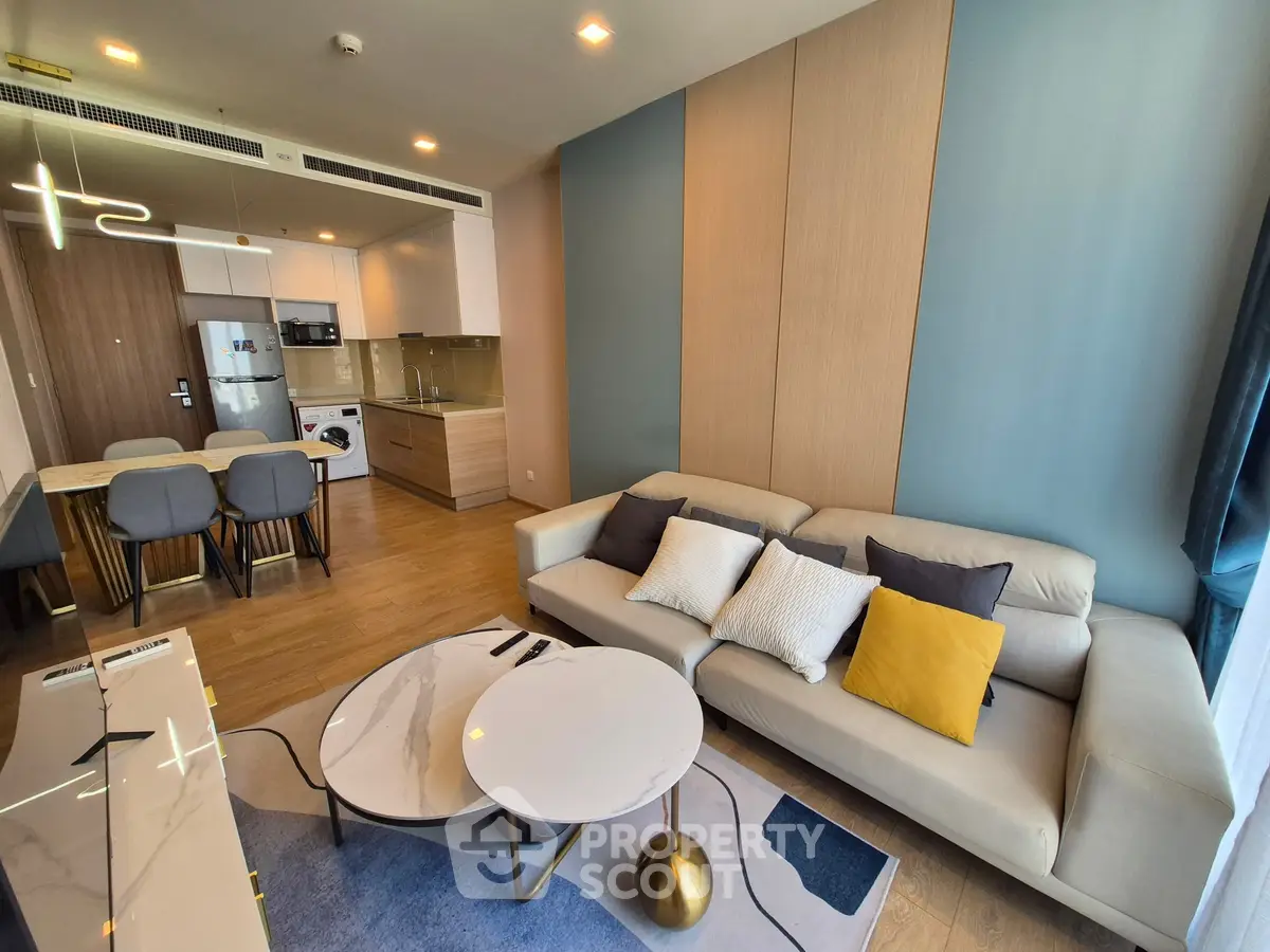 Modern living room with stylish furniture and open kitchen layout