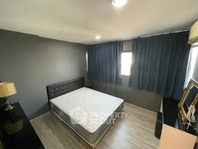 Modern bedroom with stylish decor and natural light, featuring a comfortable bed and sleek furnishings.