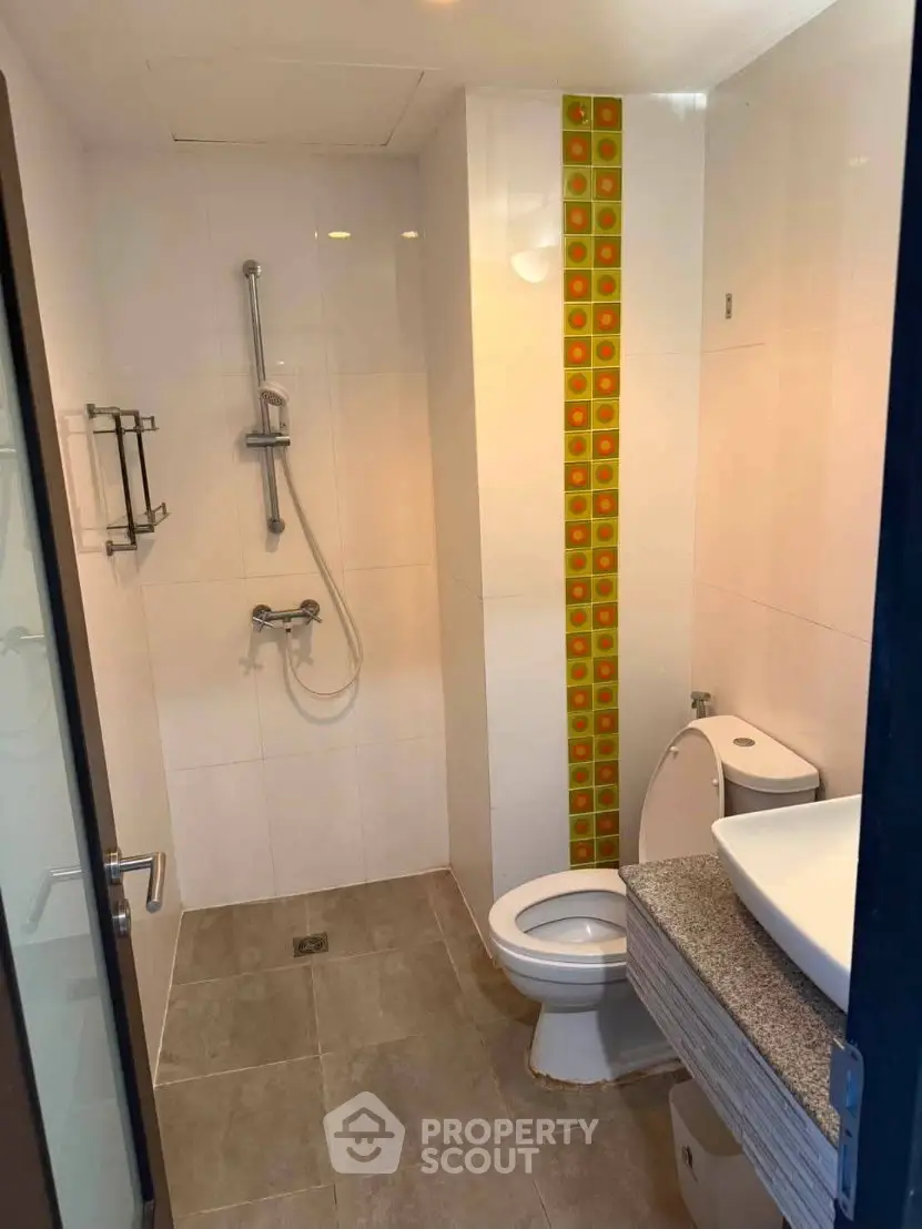 Modern bathroom with shower and stylish tile accent wall