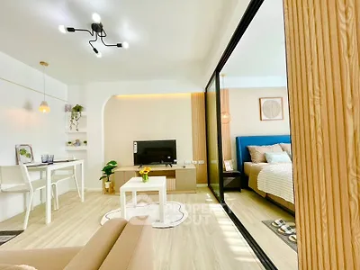 Modern open-plan living room with stylish decor and cozy bedroom view.