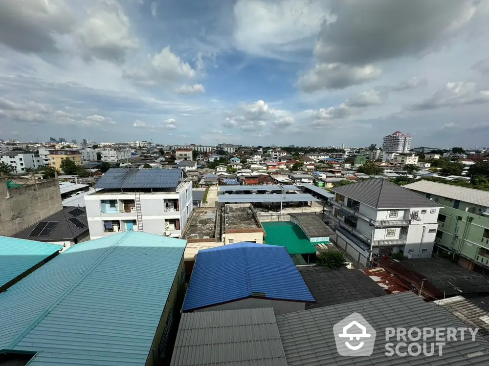 Stunning aerial view of urban residential area with diverse rooftops and expansive skyline.