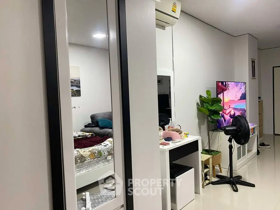 Modern living room with cozy decor and wall-mounted TV, perfect for relaxation.