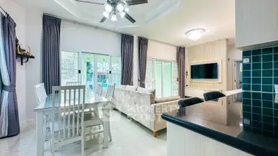 Spacious modern living room with open kitchen and elegant dining area, featuring stylish decor and ample natural light.