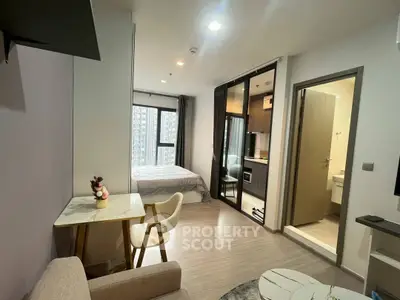 Modern studio apartment with open layout and city view, featuring a cozy living area and compact kitchen.