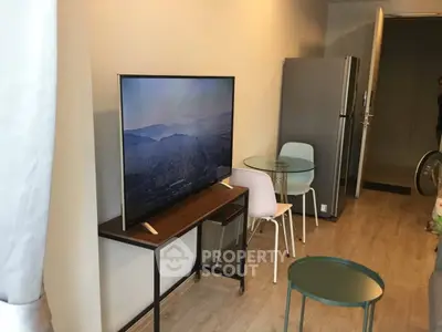 Modern living room with sleek TV, stylish furniture, and open layout in a contemporary apartment.