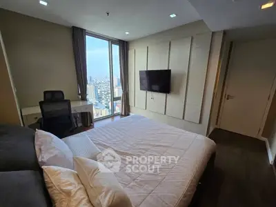 Luxurious bedroom with city view, modern decor, and wall-mounted TV