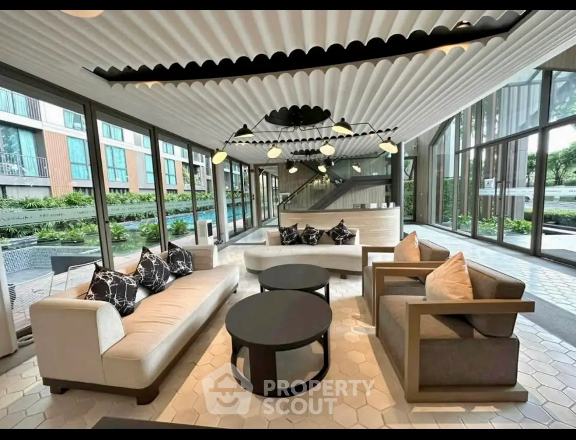 Modern living room with stylish furniture and large windows overlooking garden view.