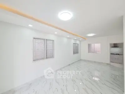 Spacious modern living room with marble flooring and ample natural light